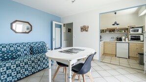 A compact living space with a sofa, a dining table, and a kitchenette.