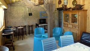 A rustic wooden interior with a stone wall, wooden furniture, and a kitchenette. - Charming Studio with Garden and Terraces, Peaceful and Historic Setting (Mersuay)
