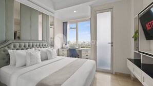 A modern hotel room with a large bed, a desk, and a TV. - Halden by Kozystay - Menteng (Jakarta)