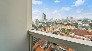 A cityscape view from a window, featuring a mix of modern and traditional buildings, a prominent skyscraper, and a clear blue sky. - Halden by Kozystay - Menteng (Jakarta)