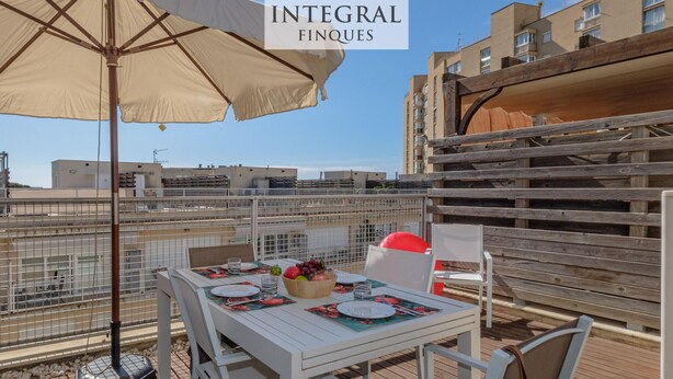 A rooftop terrace with a table set for dining, a large umbrella, and a view of the cityscape. - Charming triplex with jacuzzi in Calonge (Calonge)