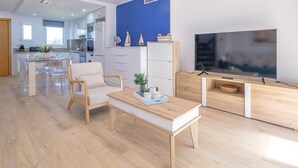 A modern living room with a wooden coffee table, clear chairs, a sofa, and a TV. - Charming triplex with jacuzzi in Calonge (Calonge)