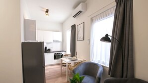 A compact living space with a kitchenette, a dining area, and a seating area with a plant. - Modern apartment near Scheveningen beach (Den Haag)