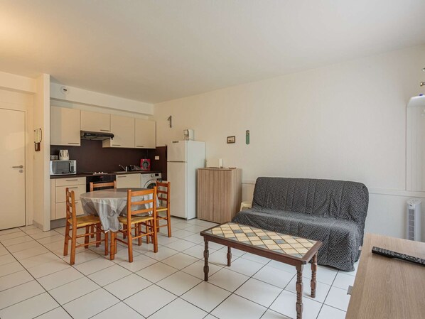 A compact living space with a kitchenette, a dining area, and a sofa.