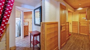 A hallway with wooden walls and doors, a mirror, and a small table. - La Clusaz - Apartment 6 ppl, 53 sqm, 2 bedrooms, WiFi (La Clusaz)