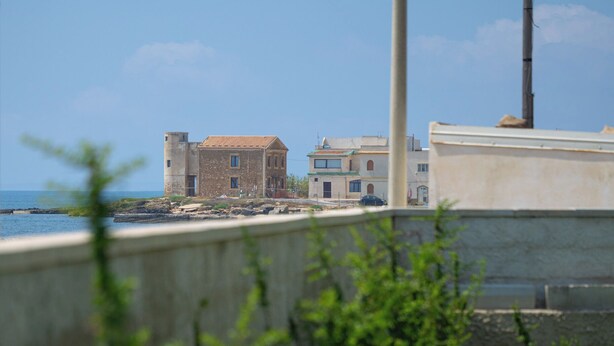 A coastal building with a view of the sea, a concrete wall, and some greenery in the foreground. - Kymè - One Bedroom Apartment, Sleeps 4 (NOTO)