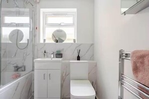 A modern bathroom with a glass shower enclosure, a white toilet, a marble vanity, and a towel rack. - Cosy Central Home with Private Garden & Fast Wifi, Comfy 3BR Home • Contractor Friendly • Town Centr... (Colchester)