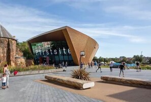 A modern building with a unique angular design, a large glass facade, and the word "Firstsite" on the front. - Cosy Central Home with Private Garden & Fast Wifi, Comfy 3BR Home • Contractor Friendly • Town Centr... (Colchester)