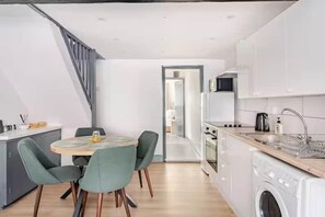 A modern kitchen with a dining area, a washing machine, and a staircase. - Cosy Central Home with Private Garden & Fast Wifi, Comfy 3BR Home • Contractor Friendly • Town Centr... (Colchester)