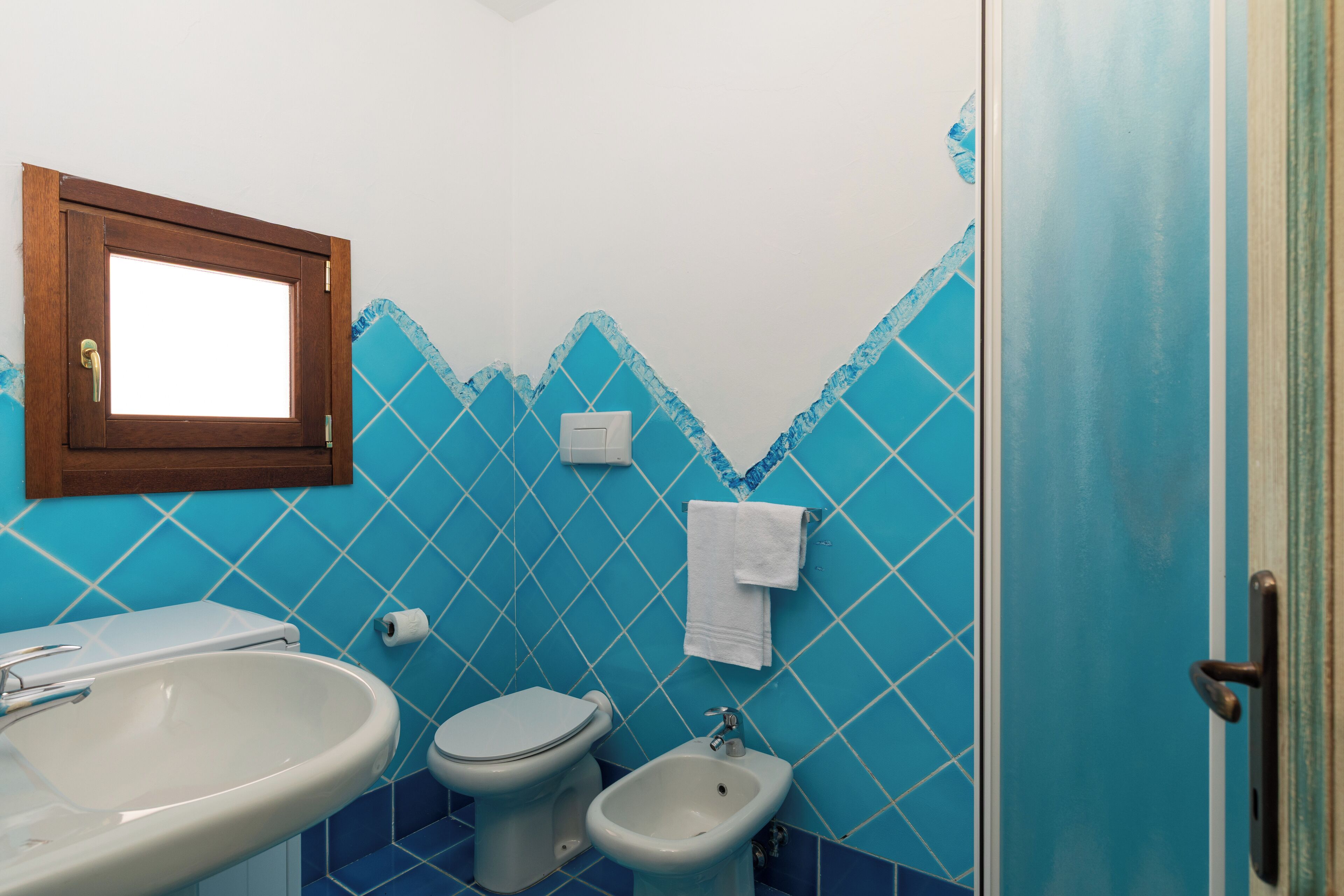 A bathroom with a toilet, bidet, and sink.