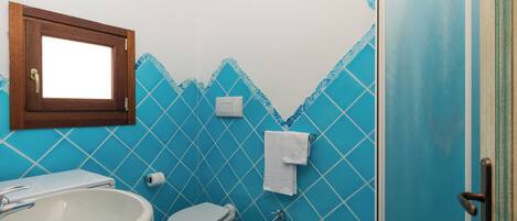 A bathroom with a toilet, bidet, and sink.