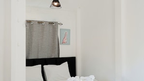 Una camera da letto con un letto, un lampadario, un portaserviti e un quadro appeso al muro.