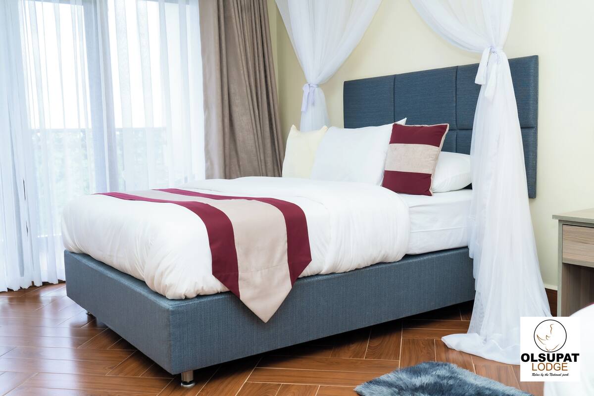 Un dormitorio moderno con cama, cortinas y un logo.