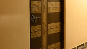 A door with a vertical panel design, a lock, and a keyhole. - Gauri Shankar P Guest house (Varanasi)