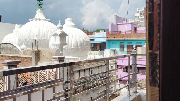 A view of a building with white domes and a balcony with a metal railing. - Gauri Shankar P Guest house (Varanasi)