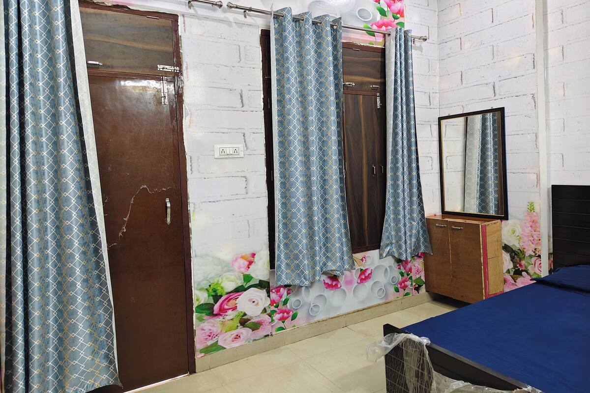 A bedroom with a bed, a wardrobe, and a mirror.