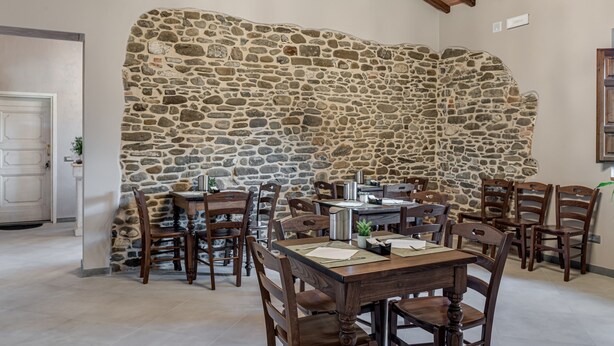 A dining area with stone walls, wooden tables, and chairs. - Room 'Il Borghetto Lavanda' with Shared Garden, Wi-Fi and Air Conditioning (Borgo San Lorenzo)
