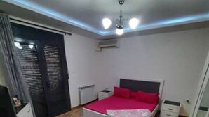 Un dormitorio con cama, mesitas de noche, escritorio y armario.