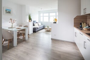 Een moderne keuken met een eethoek, een bank en een groot raam.