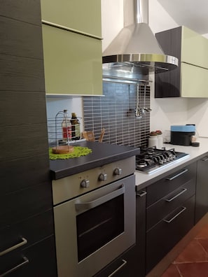 A modern kitchen with stainless steel appliances, a gas stove, and a range hood.
