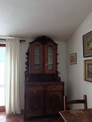 A room with a wooden cabinet, a dining table, and a chair. - Poggio Bassotto, Your Peaceful Retreat Near the Heart of Rome (Sacrofano)