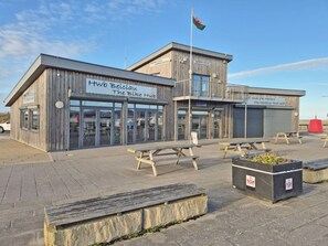 A wooden building with a sign for 'Hwb Beiciau The Bike Hub' and 'Hwb Yr Harbour Master.' - 3 bedroom accommodation in Rhyl, near Towyn (Rhyl, near Towyn)