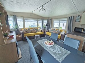 A compact living space with a sofa, dining table, and kitchenette.