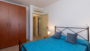 Une chambre à coucher comprenant un lit, une armoire et un appareil de climatisation.