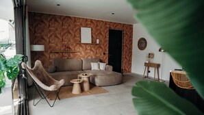 Een moderne woonkamer met een bank, een fauteuil, een salontafel en een bijzettafeltje.