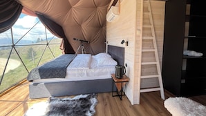Un cuarto con tienda de campaña acogedor, con una litera, un telescopio y vistas al exterior.