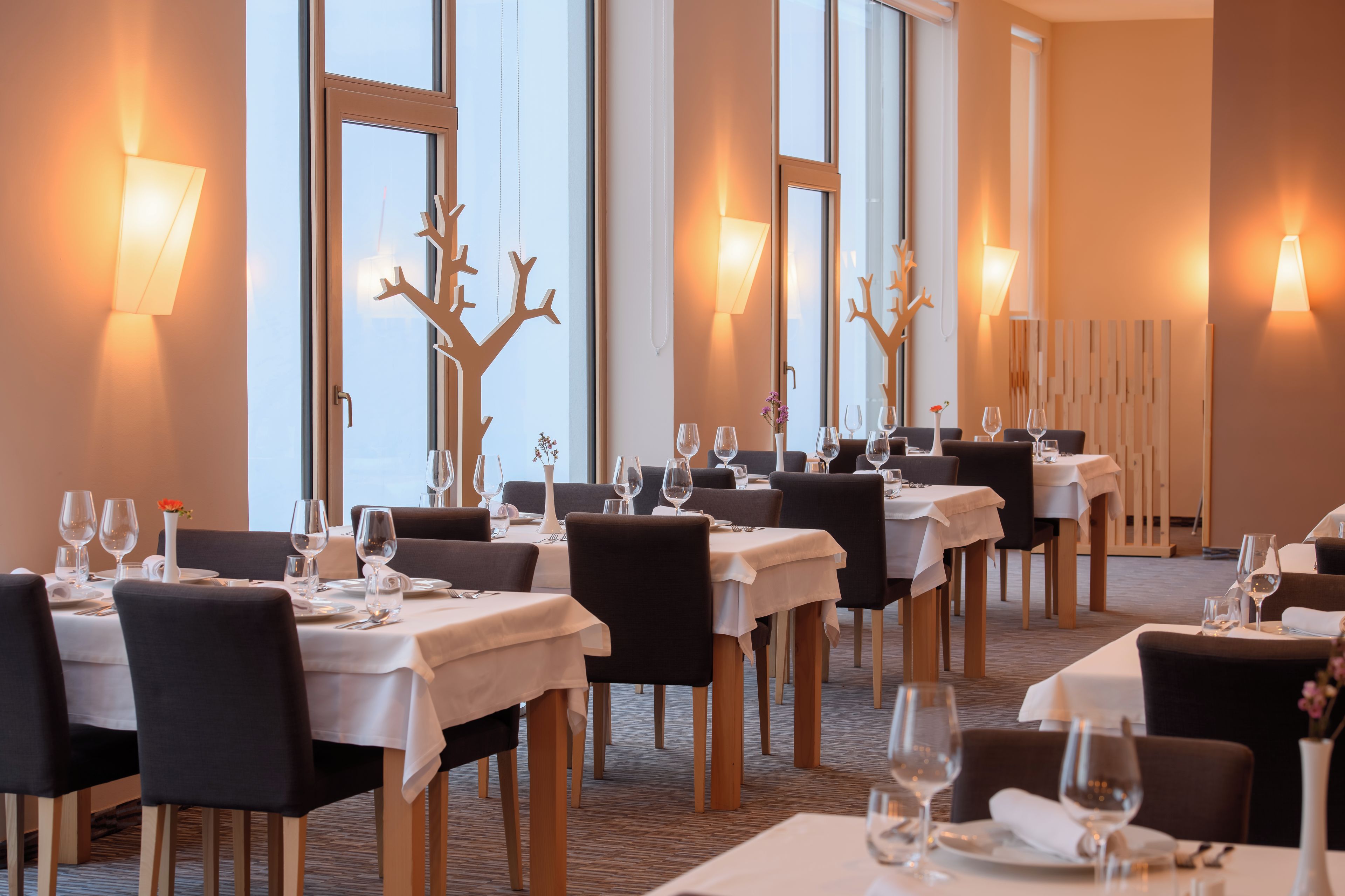 A restaurant with multiple tables set for dining, each with chairs and table settings.