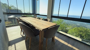 A dining area with a wooden table and chairs, large windows offering a view of the landscape. - adesa viev villas (Sapanca)