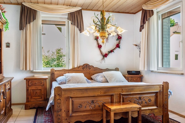 Ein Bett mit Holzkopfstück, Nachttische und einer hängenden Chandelier.