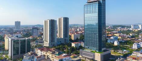 Une vue urbaine avec des immeubles modernes de grande hauteur, dont un bâtiment remarquable portant l’inscription « VINPEPARI ».