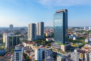 Un paisaje urbano con modernos rascacielos, incluyendo un edificio destacado con el letrero 'VINPEPARI'.