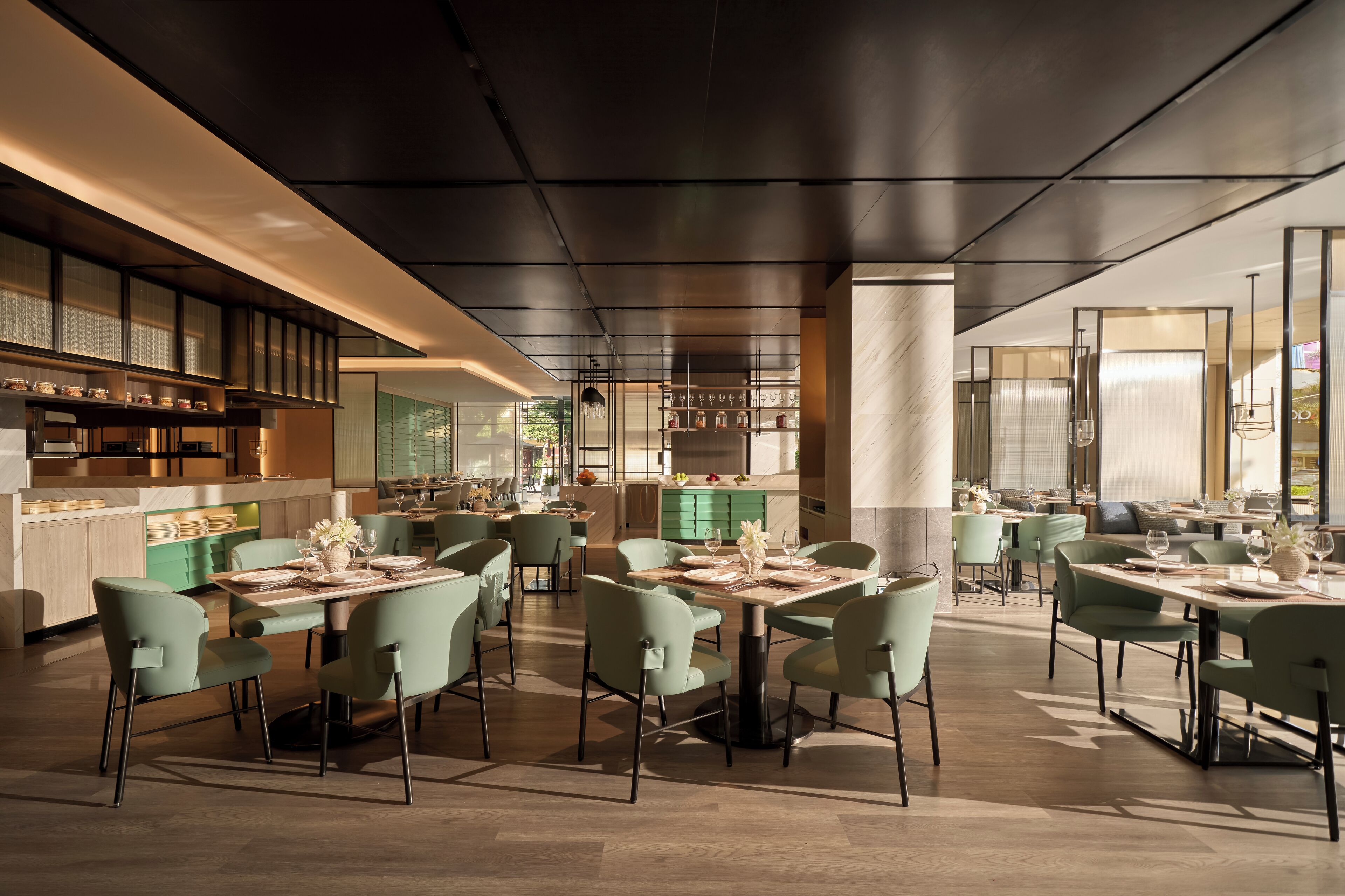 A modern restaurant with multiple dining areas, each with tables and chairs.