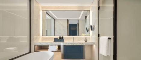 A modern bathroom with a freestanding bathtub, a vanity with a mirror, and a towel rack.