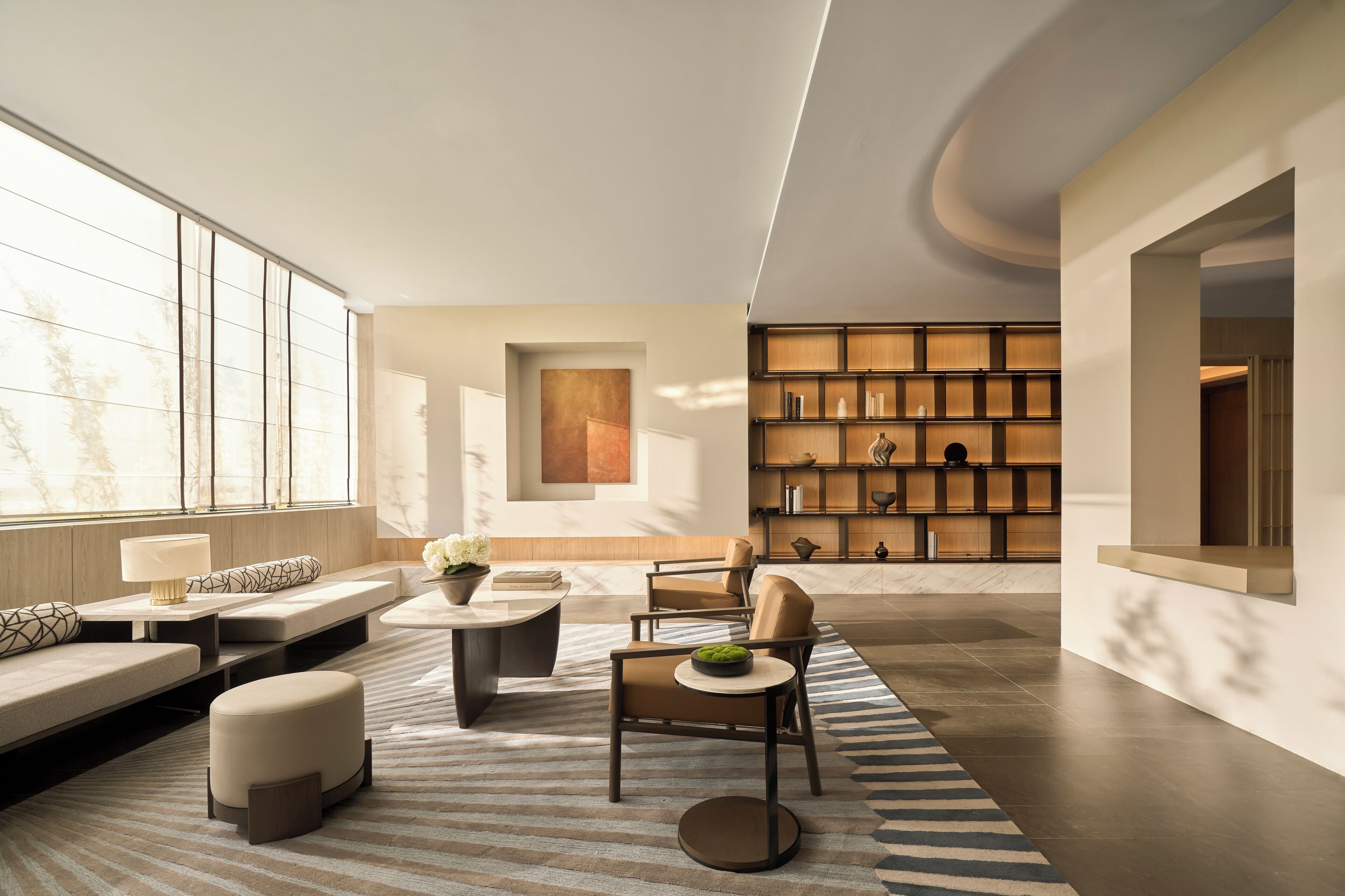 A modern interior with a seating area, a coffee table, and a bookshelf.
