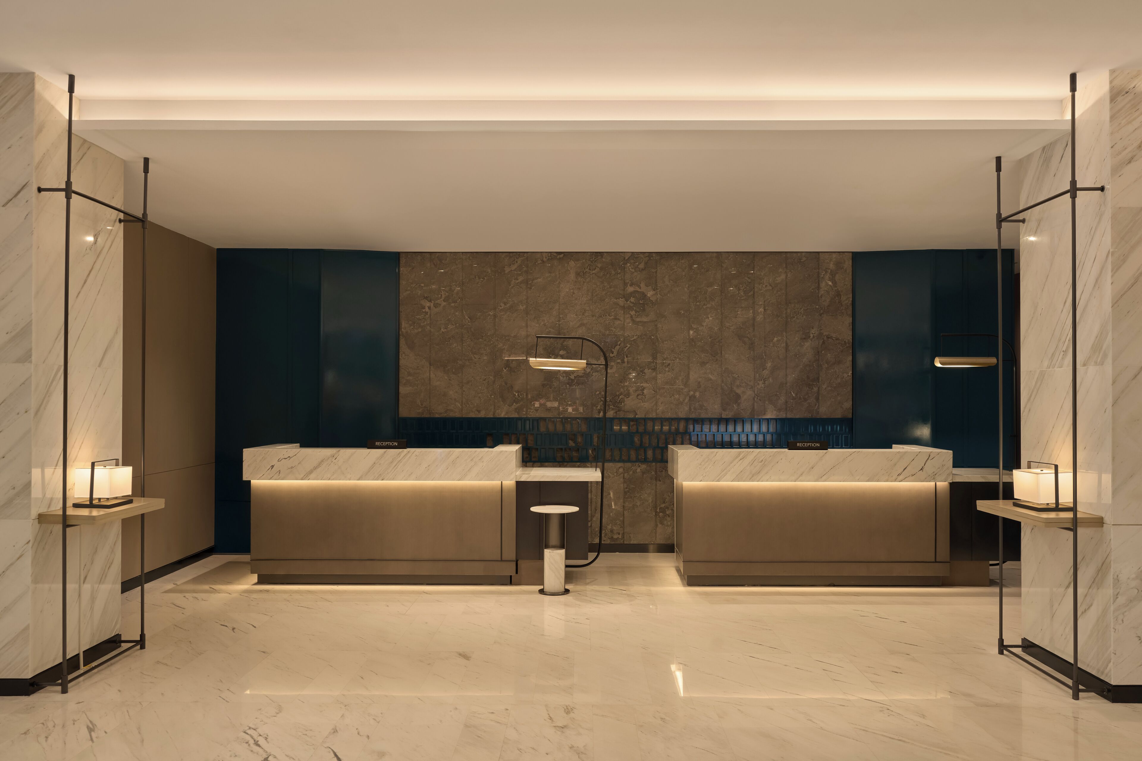 Un bagno moderno con pavimento in marmo, due lavabi e un banco reception.