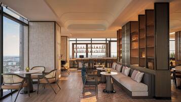 A modern lounge area with a sofa, chairs, a bar, and a large bookshelf.