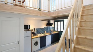 A modern kitchen with a built-in washing machine, a microwave, and a sink.