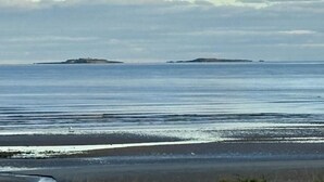 A coastal view with calm sea and distant islands.