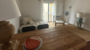 Una habitación acogedora con una mesa de comedor de madera, un sofá, una silla y una lámpara de pie.