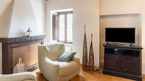 A living room with a fireplace, a television, and a window. - GuestHost - Battazzi House (Peglio)