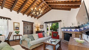 Un salon chaleureux avec un canapé, une table basse, une cheminée et un plafond en bois.