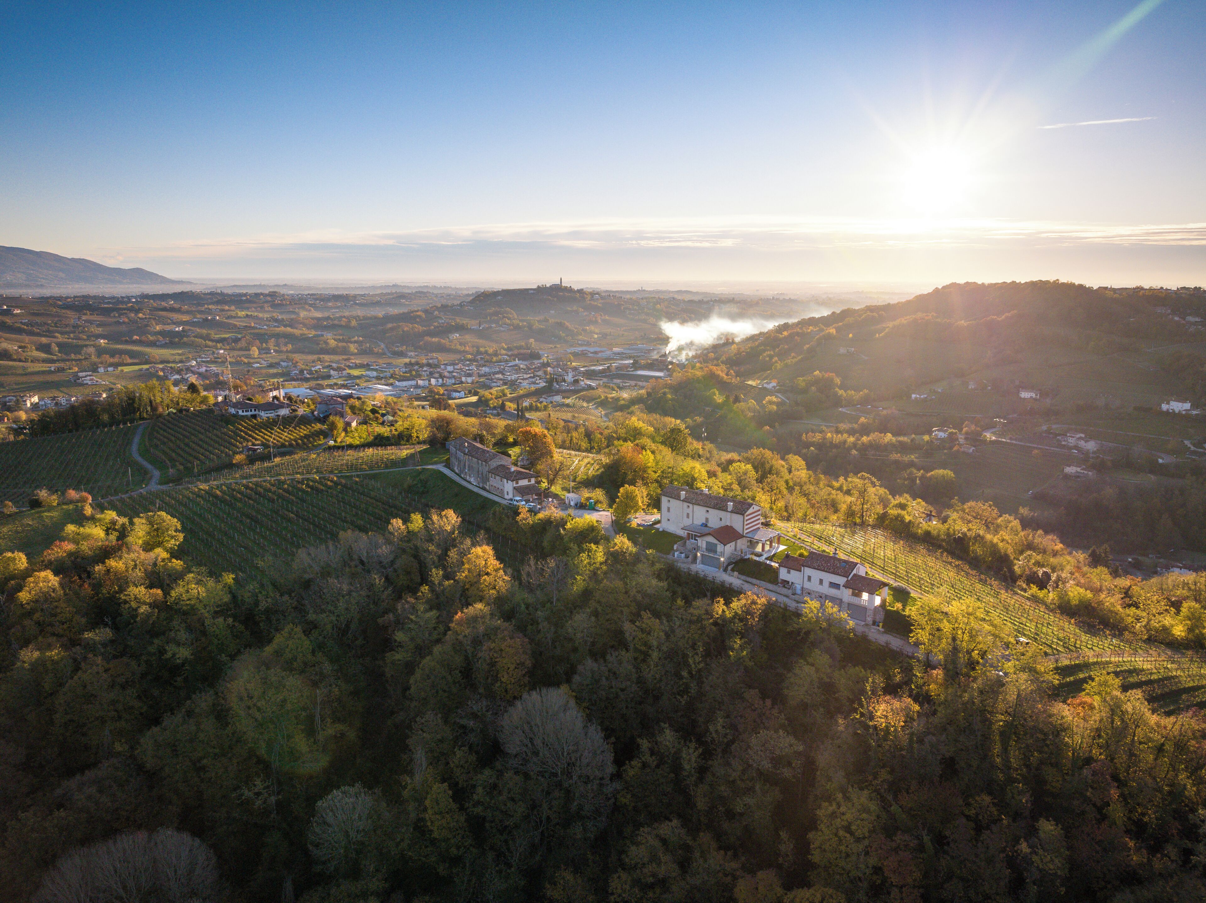 An aerial view of a vineyard with buildings and rolling hills.