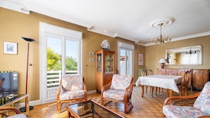 A room with a television, a dining table, and two chairs. - Holiday Home 'Maison De Caractère' with Shared Terrace, Private Garden and Wi-Fi (Cancale)