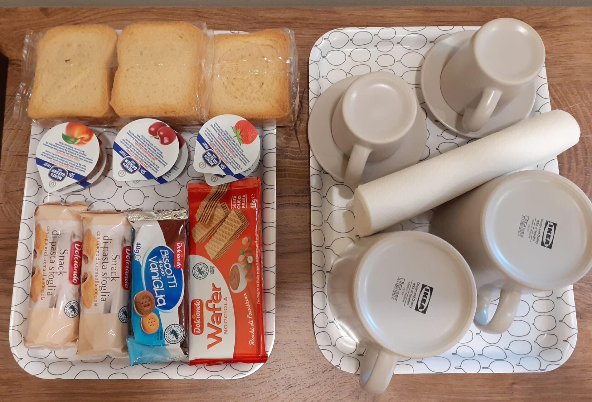 Una bandeja con diversos alimentos y un juego de tazas y platillos blancos.