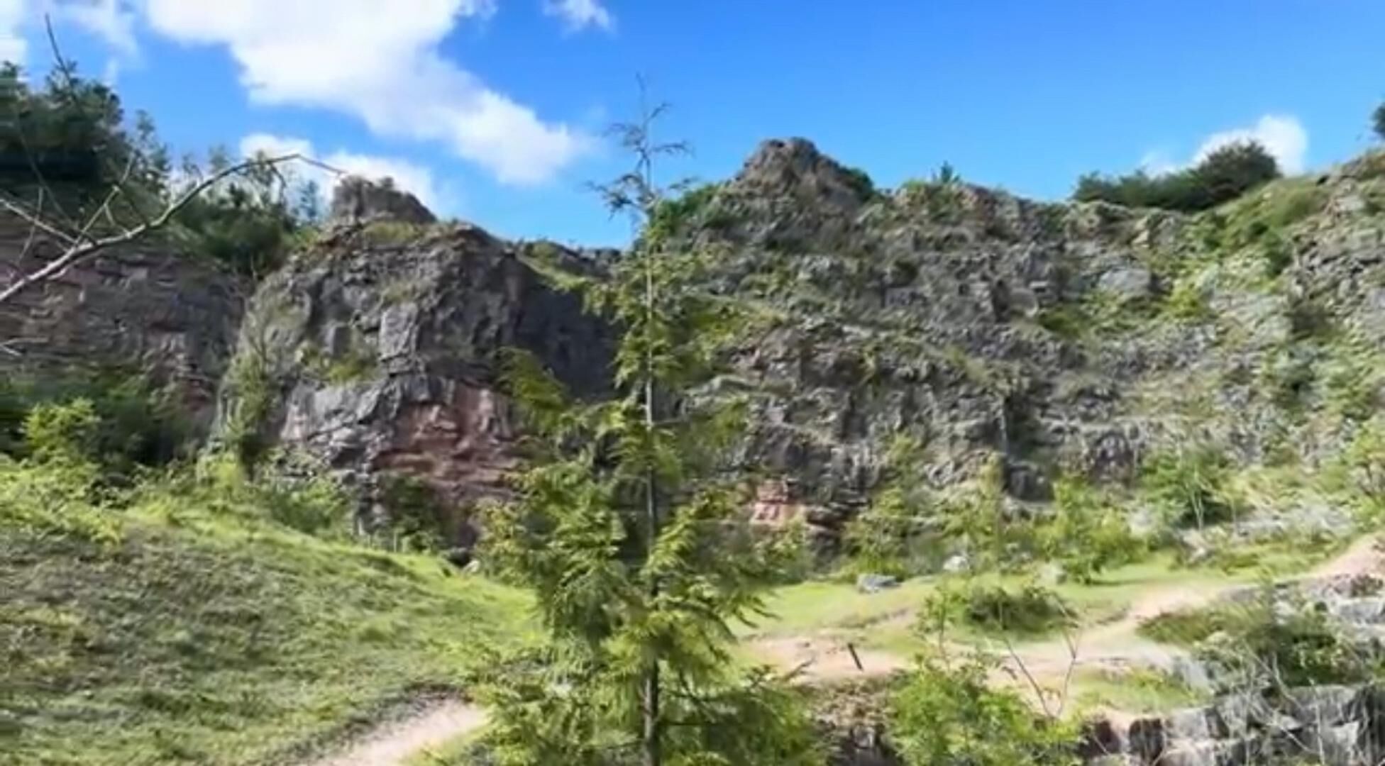 A mountainous landscape with rocky cliffs and sparse vegetation.