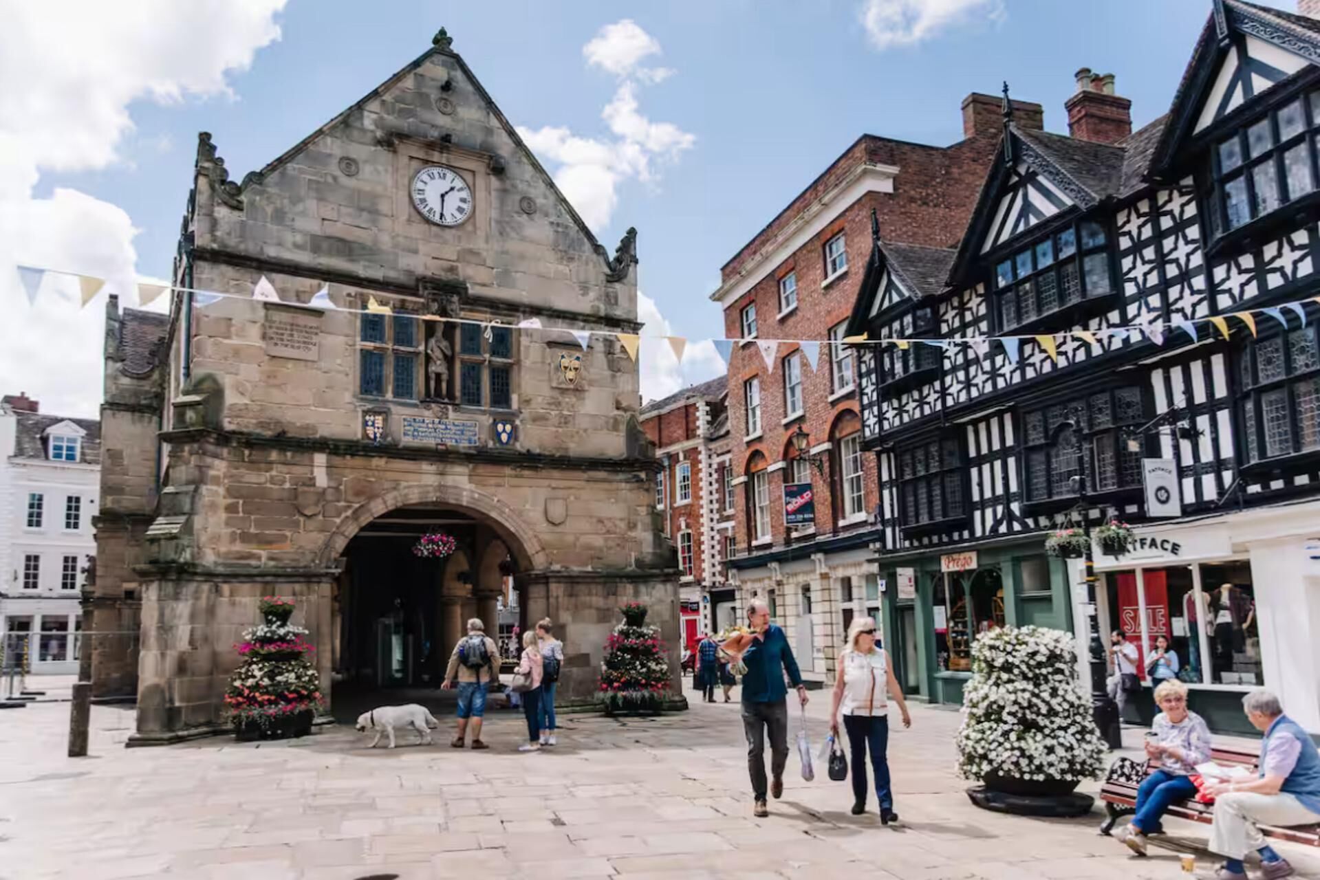 Un edificio histórico con una torre de reloj, una plaza pública y arquitectura tradicional.